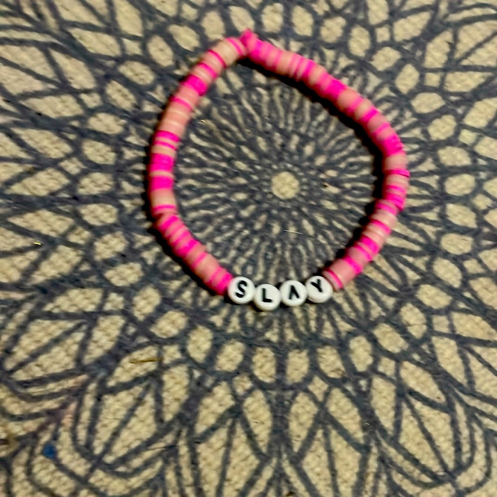 Homemade clay bead bracelet with the word “SLAY” on it.